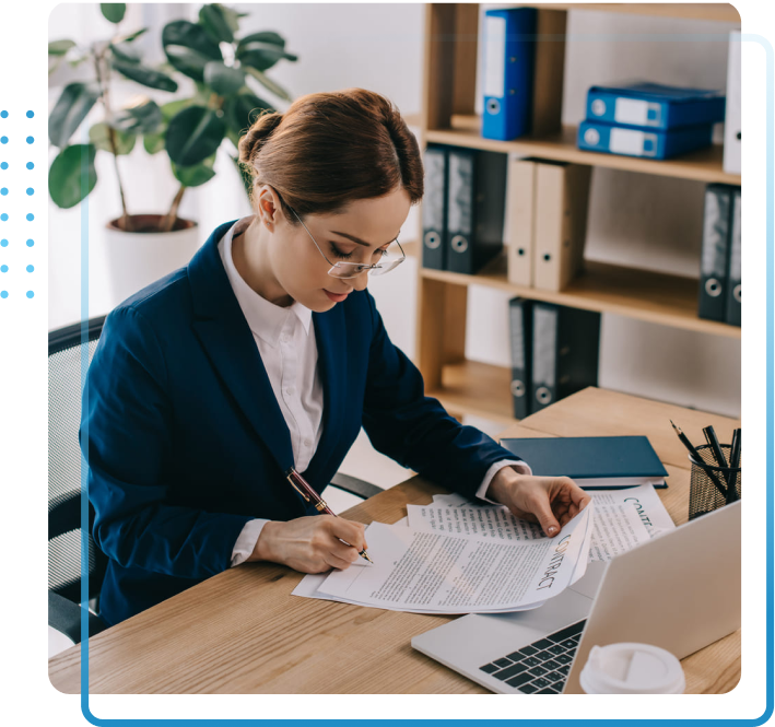 side view of female lawyer doing paperwork at workplace with laptop in office