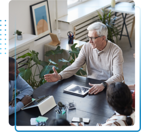 Middle aged man presenting in a meeting to his colleagues.