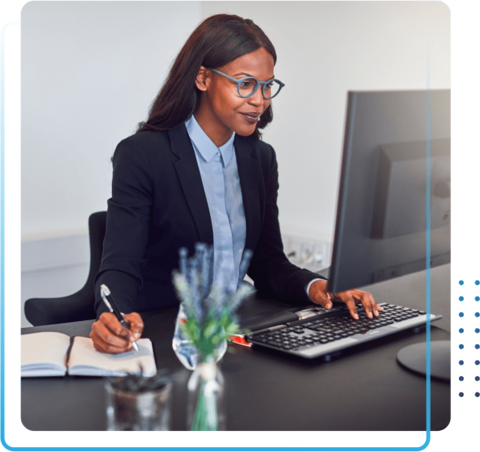 Young african american woman working on a computer and taking notes